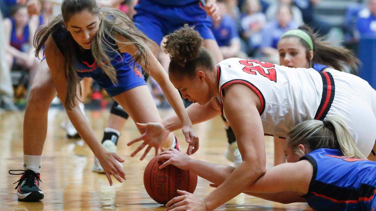 Clark County’s Tyra Flowers (22) battles for the ball with Southwestern’s Ayden Smiddy, left, and Payton Acey (55) at Lexington Catholic High School on Dec. 21, 2021. The Cardinals won 62-61.