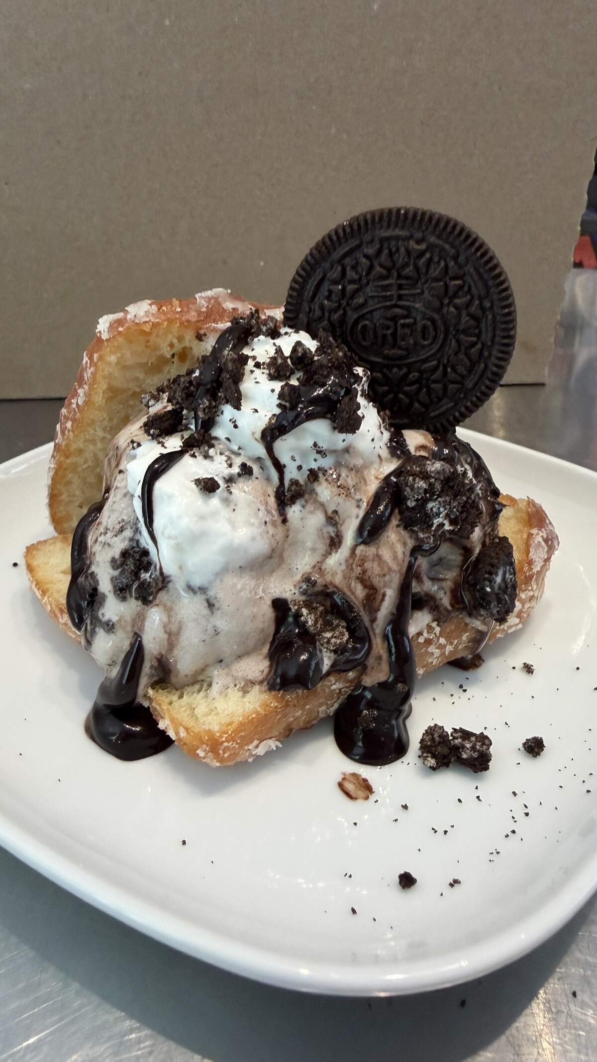Oreo Overload Burger from Crank & Boom, featuring cookies & cream ice cream, Oreo bits, whipped cream and chocolate fudge sauce all sandwiched inside a North Lime Donuts glazed donut “burger” bun.