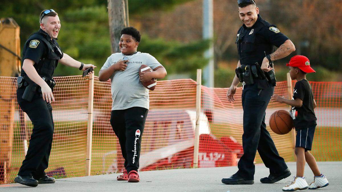 Police officers interact with children at a park in Lexington, Ky., in 2021.