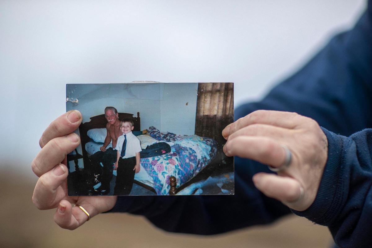 Toskia Adamson holds a photograph of her dad, Bert Adamson, and her son, Skyler Lohse, that was lost when a tornado destroyed her mother’s home in Dawson Springs, Ky., on Dec. 10, 2021, during the historic quad-state tornadoes that scoured a path of destruction nearly 200 miles. Adamson was able to recover some photos that had been blown across state lines through a Facebook group dedicated to helping reunite tornado victims with lost items.