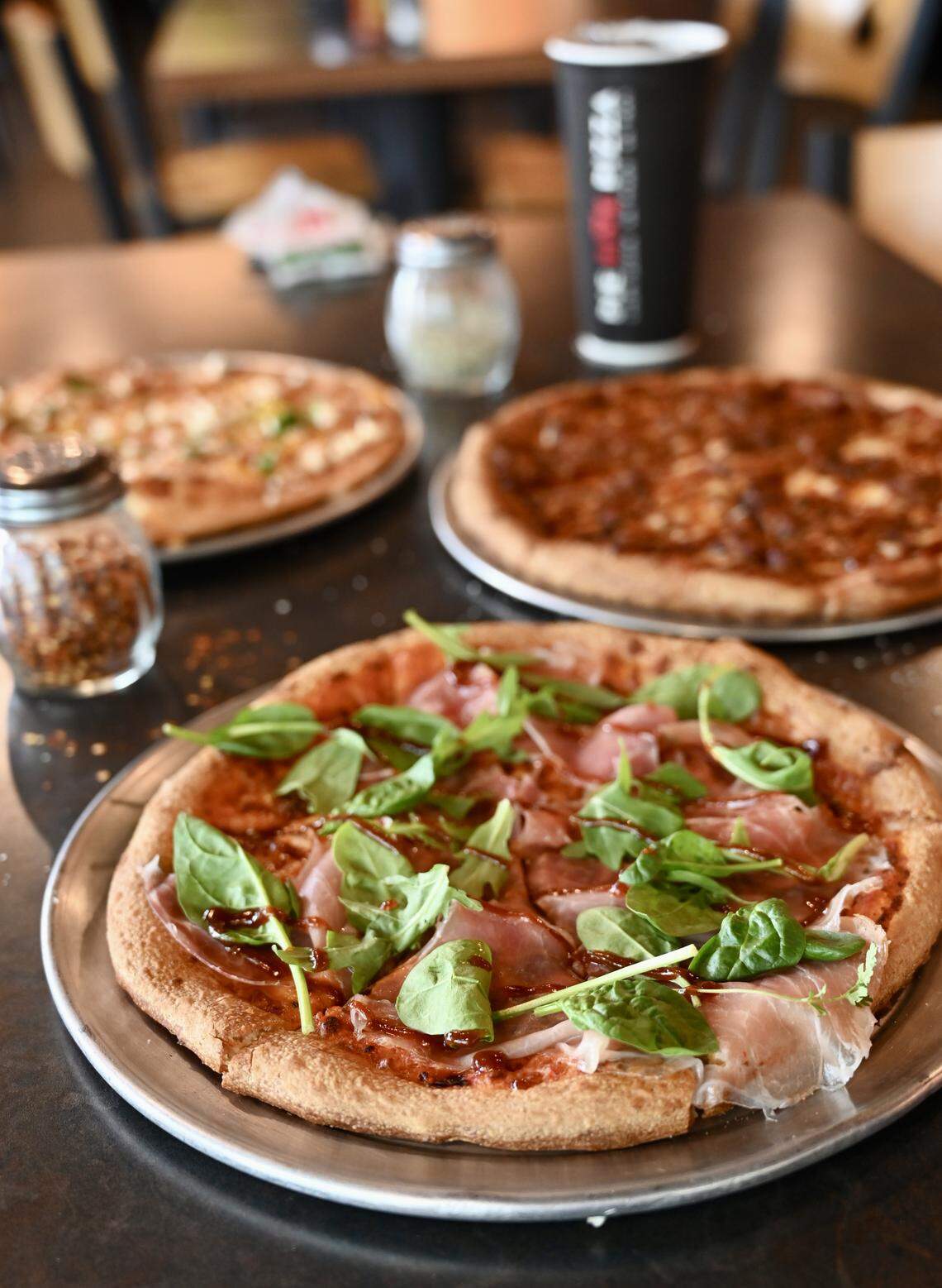 Pie Five has three options for Lexington Pizza Week 2025 including The Tipsy Prosciutto, shown in front. It’s topped with creamy vodka sauce, prosciutto and fresh, peppery arugula.