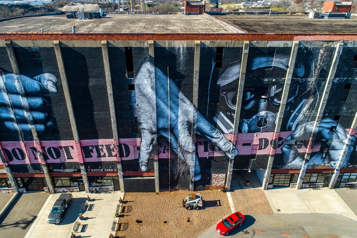 The mural on the former barrel warehouse depicts French artist MTO signing his name. U-Haul may have to add exterior elevators to the building.