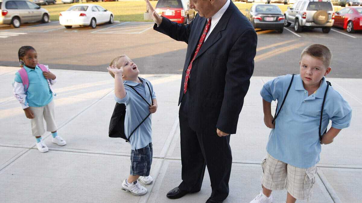 Stu Silberman got a high-five from 5-year-old Ryan Goodwin while his brother Jaden, 6, and 5-year-old Aja Coffey, left, looked on as the superintendent greeted kids on the first day of school at Liberty Elementary School on Aug. 13, 2008.
