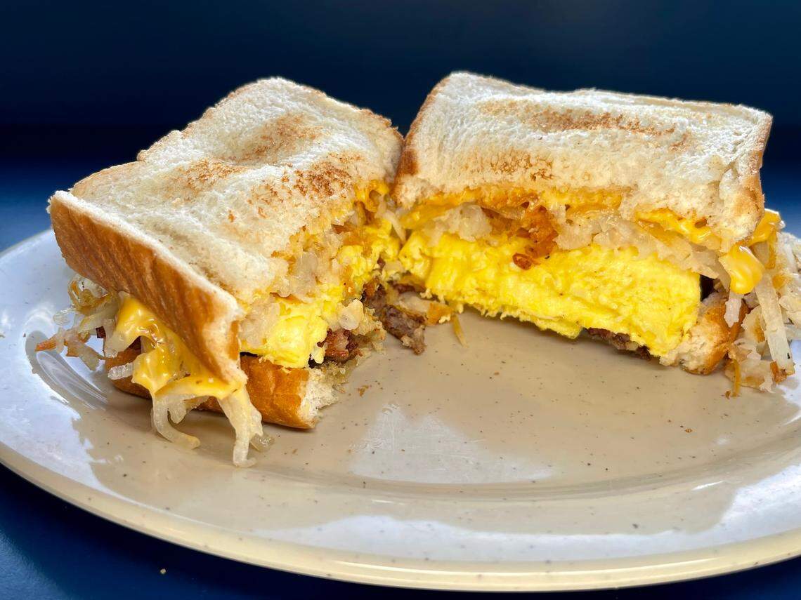 Tolly-Ho’s Hot Mess sandwich. Two strips of bacon, two sausage patties, two eggs, hashbrowns, and a slice of American cheese on buttered Texas toast.