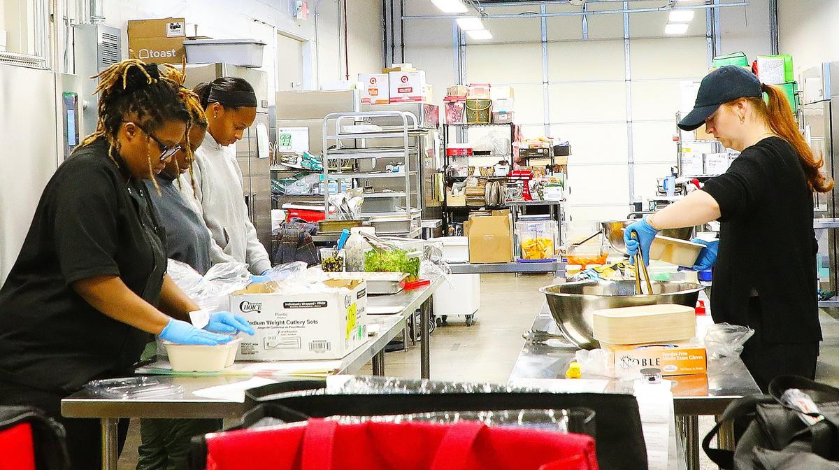“Packed” Manager Mikaili Sturges joins the assembly line after performing food preparation, moving into packaging with her team at Greyline Station’s Julietta Market Kitchen early in the morning on December 3, 2024, in Lexington, KY
