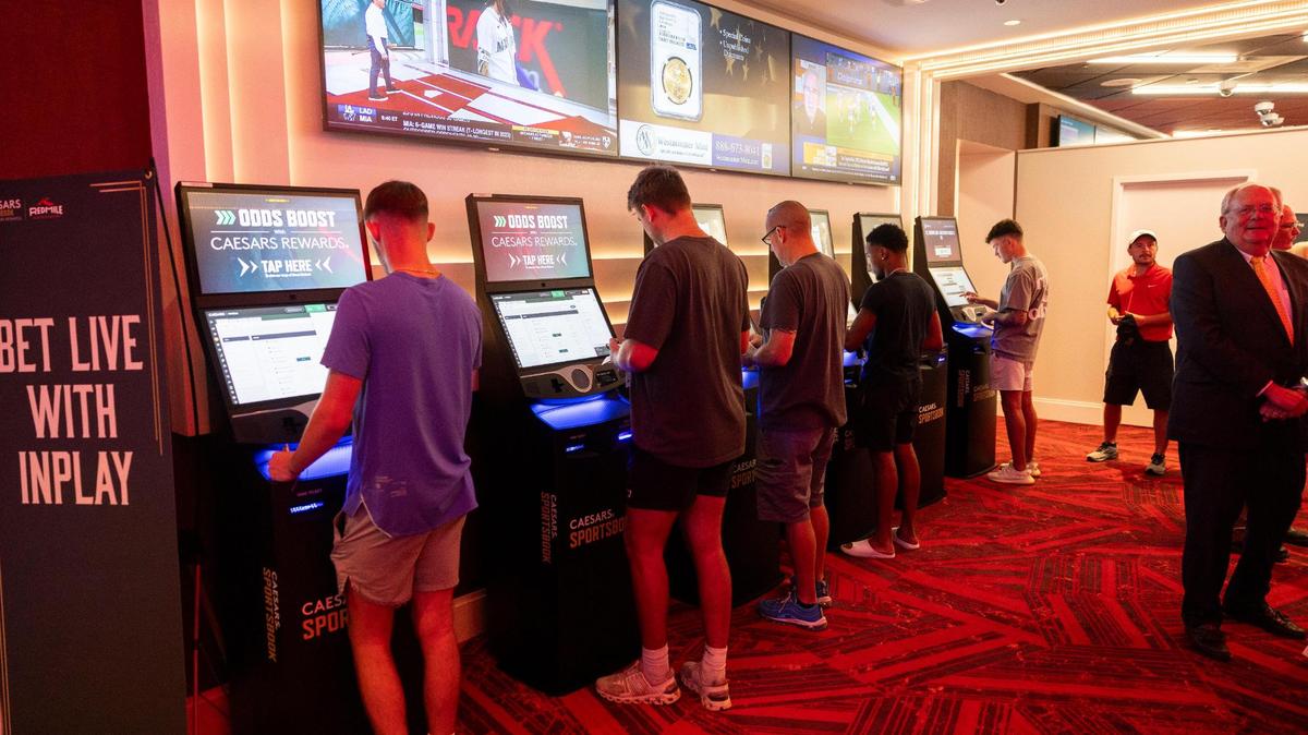 Patrons place bets after a press conference where Gov. Andy Beshear announces the opening of a Caesars Sportsbook and made comments on the first day of sports betting legalization in the Commonwealth at Red Mile in Lexington, Ky, Thursday, September 7, 2023.