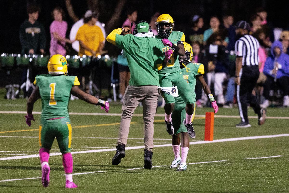 Bryan Station wide receiver Demond Green (9) celebrates with an assistant coach after scoring a touchdown during the Defenders’ game against George Rogers Clark at Bryan Station High School on Friday.