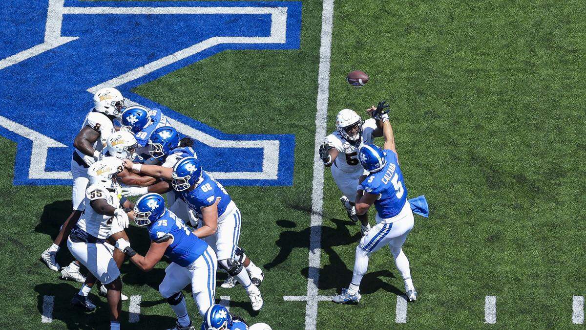 Kentucky quarterback Zach Calzada (5) throws a first-quarter interception while under pressure from Toledo defensive end Anthony Dunn Jr. (58) during Saturday’s game at Kroger Field.