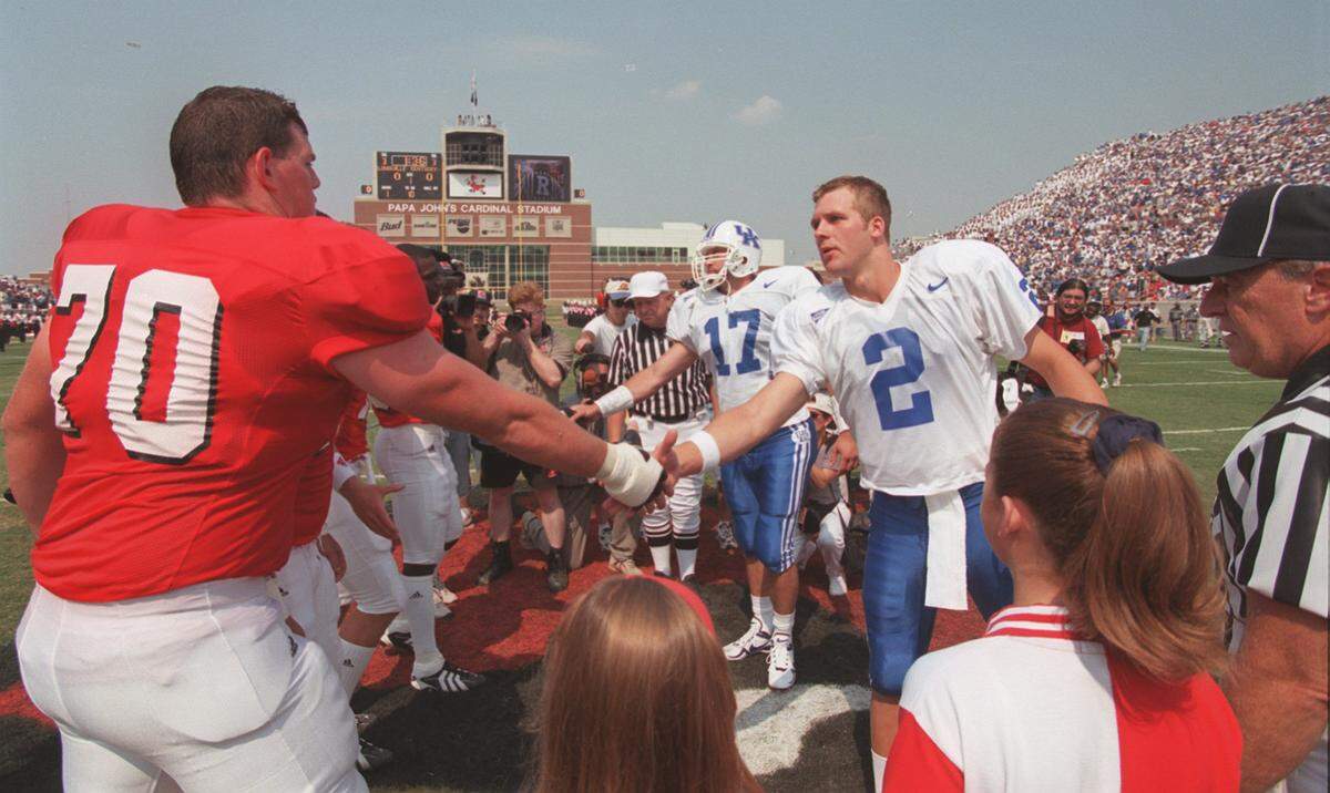 Kentucky team captain Tim Couch (2) greeted Louisville’s Rick Nord (70) prior to the opening coin toss before the first game ever played at U of L's Cardinal Stadium on Sept. 5, 1998. UK won the game 68-34.