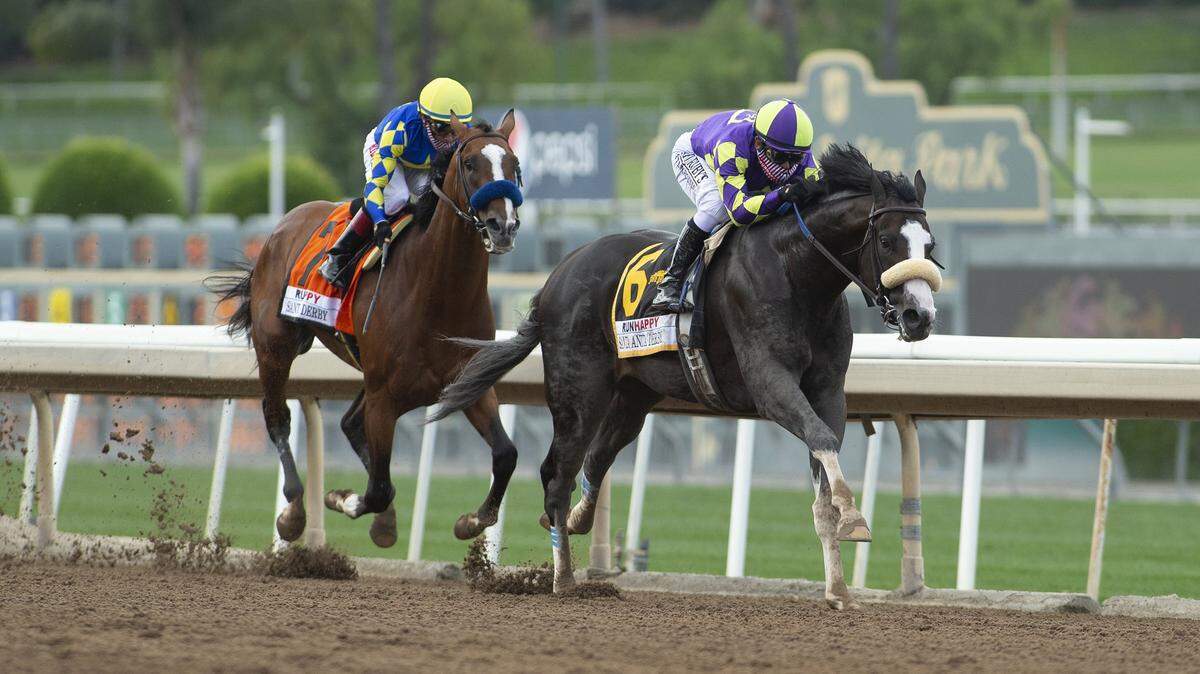 In a photo provided by Benoit Photo,C R K Stable’s Honor A.P. and jockey Mike Smith, right, glide by Authentic and jockey Drayden Van Dyke in mid-stretch and to on to win the Grade I $400,000 RUNHAPPY Santa Anita Derby Saturday, June 6, 2020 at Santa Anita Park in Arcadia, Calif.
