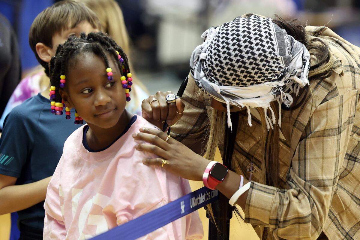 Former Kentucky great Rhyne Howard signs an autograph for a young fan during Thursday night’s game against Alabama in Lexington.