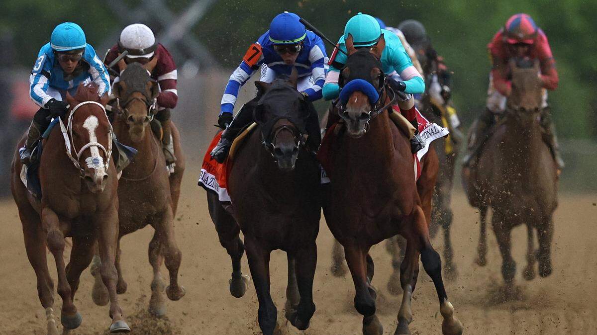 Jockey John Velazquez atop National Treasure, right, rides alongside Irad Ortiz Jr. aboard Blazing Sevens as the two close in on the finish line Saturday. National Treasure won by a head.
