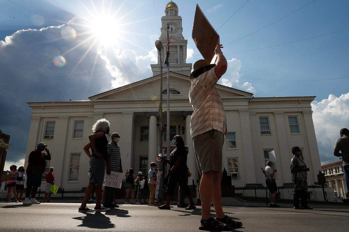 Nick Neises, of Winchester, Ky., holds a sign with others during the Together for Justice march in downtown Winchester, Ky., Friday, June 19, 2020. The march began at the Clark County Courthouse and ended at Heritage Park with a Juneteenth ceremony.