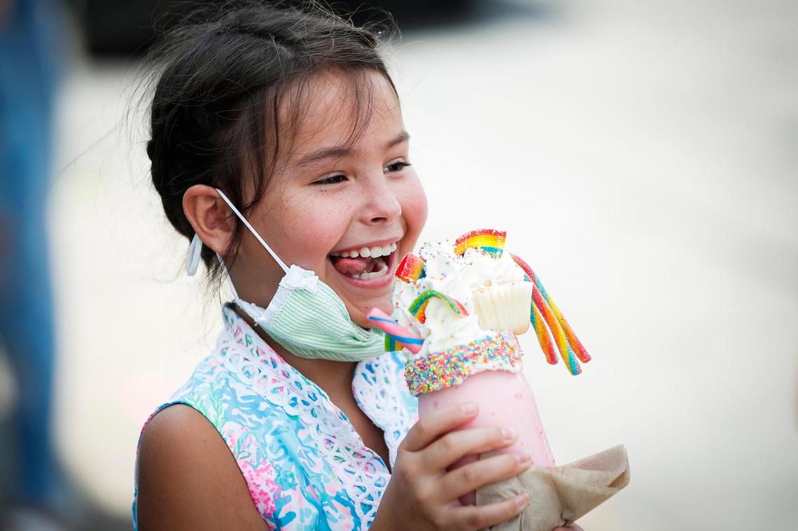 Eloise Weinberg, 9, of Louisville, reacts after receiving a Unicorn Milkshake made with Blue Bell Pink Thing ice cream and topped with sprinkles, gummy straws and belts, whipped cream and a cupcake at Sweet Matriarch Bakery in Georgetown, Ky., Saturday, Aug. 15, 2020.