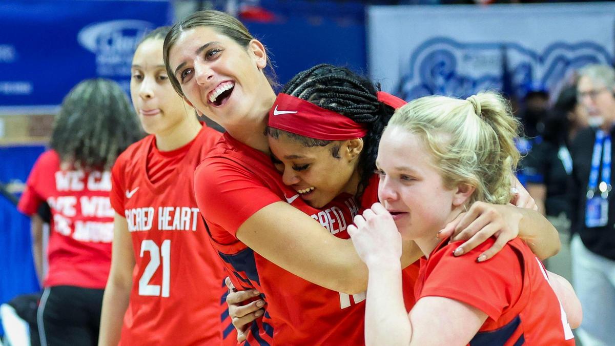 Sacred Heart’s ZaKiyah Johnson, second from right, is embraced by teammates Greer Wathen, left, and Gabby DeCamillis afer the Valkyries defeated George Rogers Clark 65-60 in the 2025 Clark’s Pump-N-Shop Girls’ Basketball Sweet 16 championship game at Rupp Arena on Saturday.