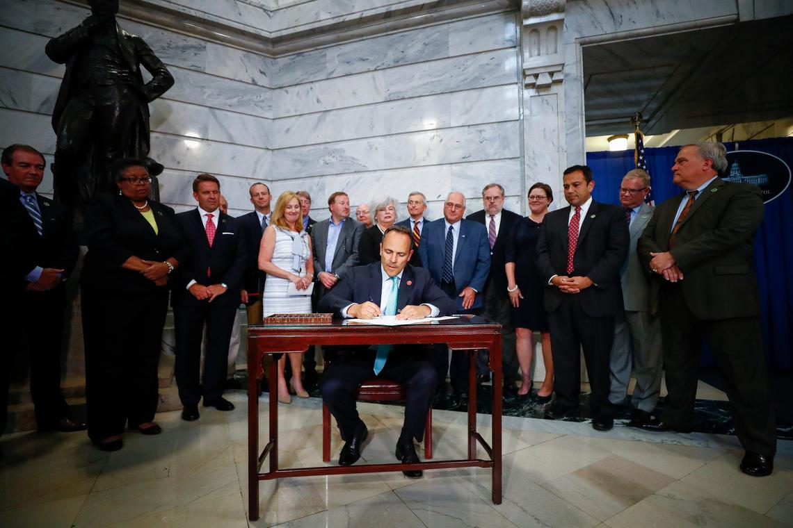 Kentucky Gov. Matt Bevin signs House Bill 1 into law in the Capitol Rotunda in Frankfort, Ky., Wednesday, July 24, 2019. The bill provides financial incentives for regional universities and quasi-governmental agencies to leave the state pension system.
