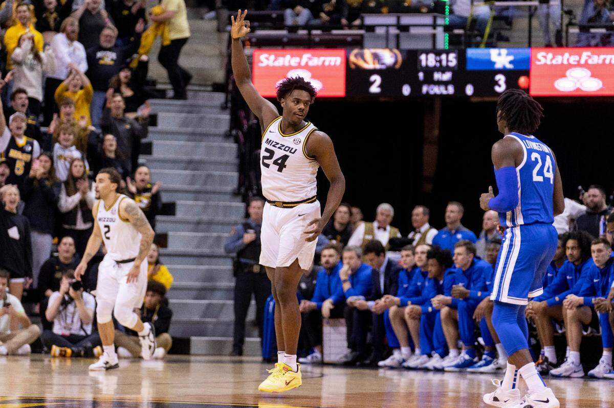 Missouri’s Kobe Brown, center, celebrates a three-point basket in front of Kentucky’s Chris Livingston, right, during the first half Wednesday in Columbia, Mo.