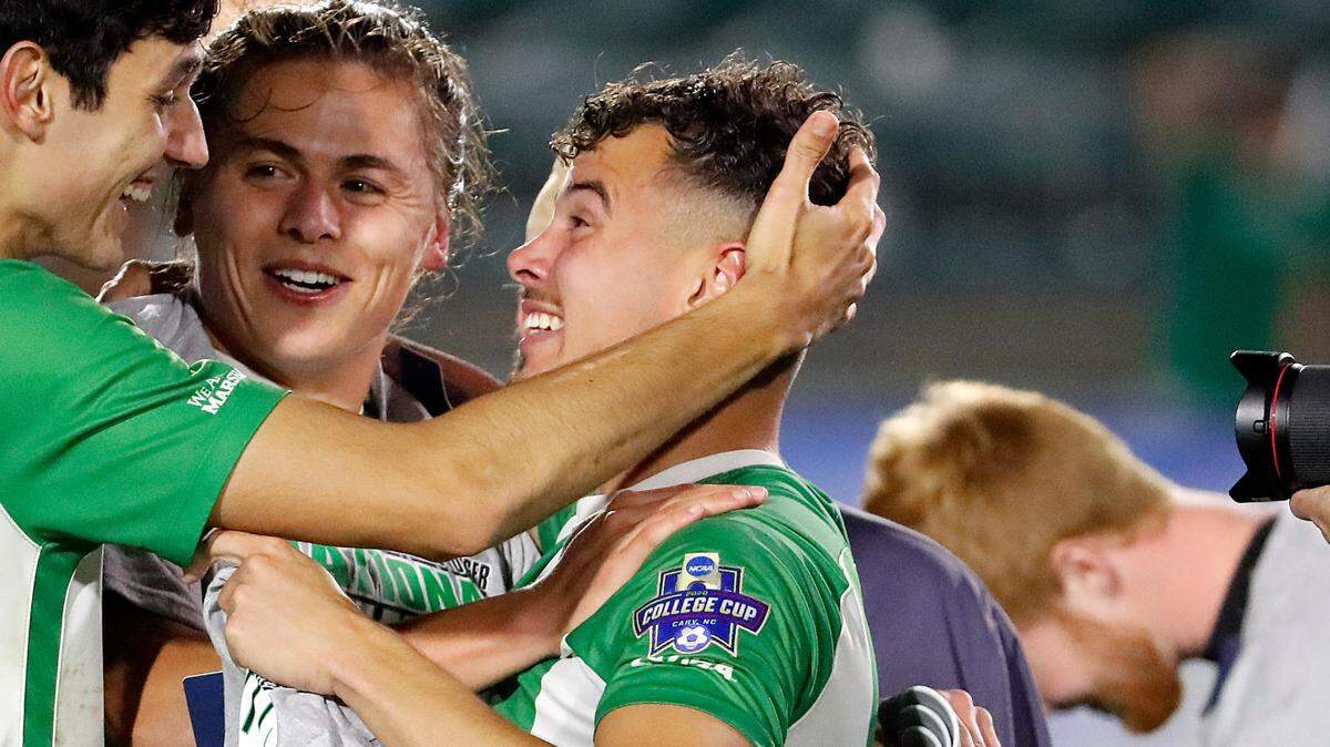 Marshall’s Pedro Dolabella (10), Max Schneider, center, and Jamil Roberts, right, celebrate following the team’s 1-0 overtime win over Indiana at the NCAA College Cup championship soccer match in Cary, N.C., Monday, May 17, 2021. (AP Photo/Karl B DeBlaker)