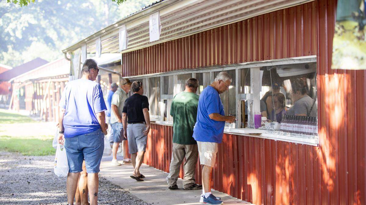 People gather to eat barbecue, play carnival games and bingo before politicians and candidates delver speeches during the 142nd annual St. Jerome picnic in Fancy Farm, Ky., Saturday, August 6, 2022.