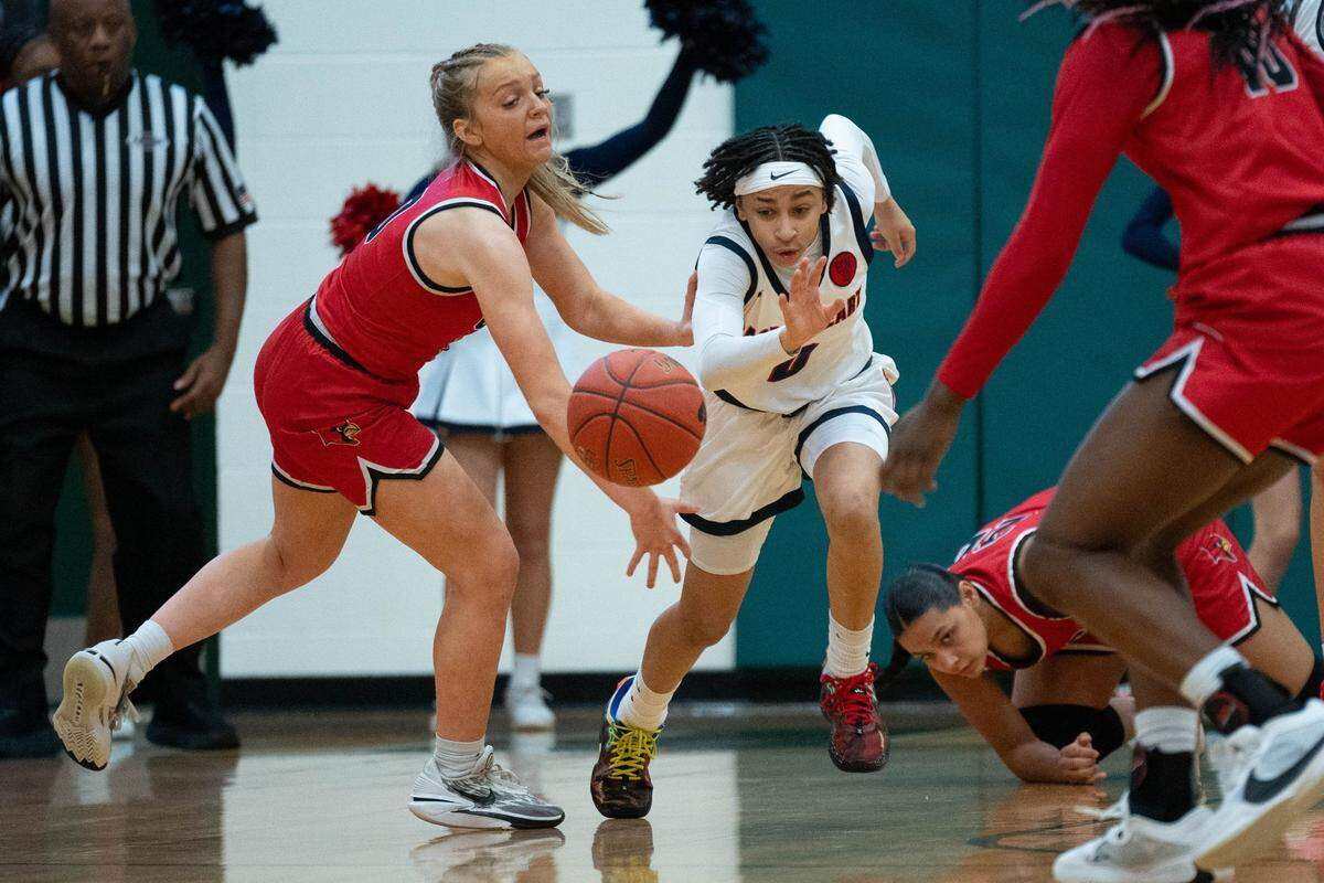 George Rogers Clark’s Kennedy Stamper, left, and Sacred Heart’s Amirah Jordan fight for the loose ball during their game on Feb. 9 at St. Xavier High School.