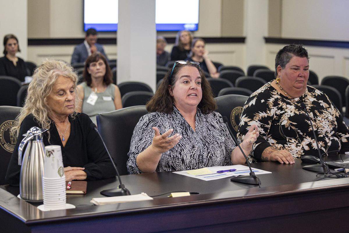 Andrea Day, center, speaks while Melissa Moore, right and Tricia Steward sit by her during an oversight hearing on Wednesday, July 30, 2025, at the Capitol Annex in Frankfort, Ky.