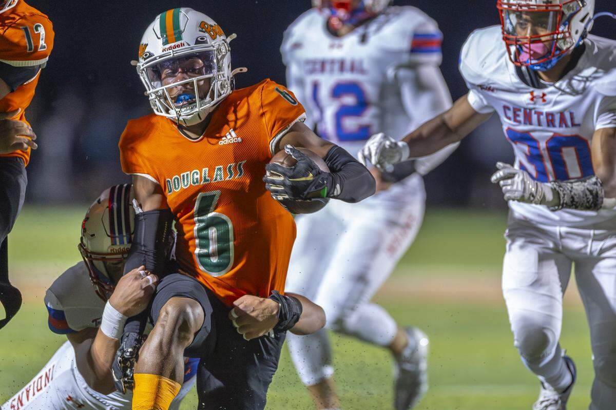 Frederick Douglass' Dakari Talbert (6) is wrapped up by Madison Central's Liam Dailey (14) during a game in Lexington, Ky., on Friday, Oct. 10, 2025.