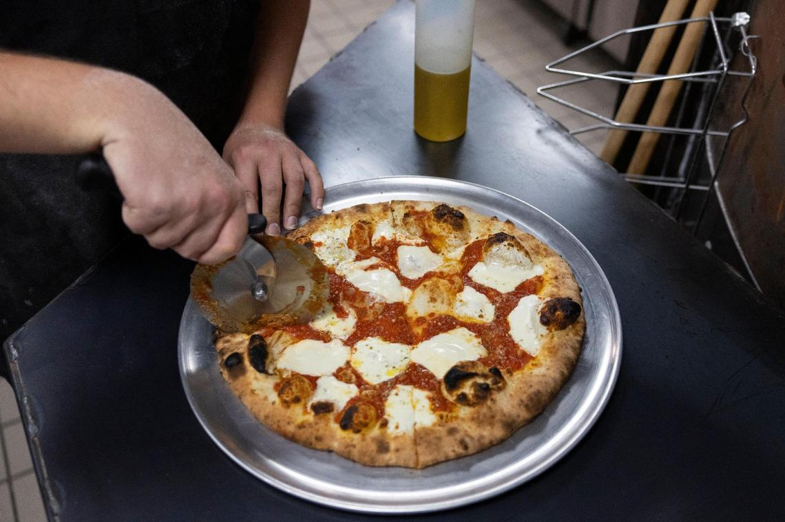 Ethereal Slice House employees prepare old world style pizza, which has a slightly charred crispy crust.