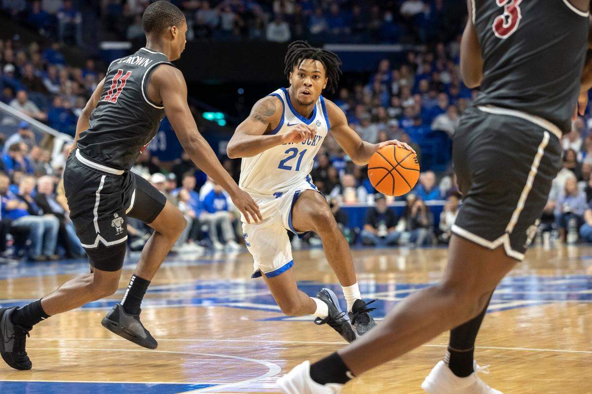 Kentucky guard D.J. Wagner (21) drives th ball as Saint Joseph’s guard Xzayvier Brown (11) defends.