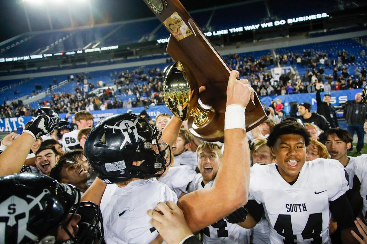 South Warren quarterback Caden Veltkamp holds up the trophy with his team while celebrating a 38-26 victory over Frederick Douglass in the 5A state finals at Kroger Field on Dec. 4, 2021.