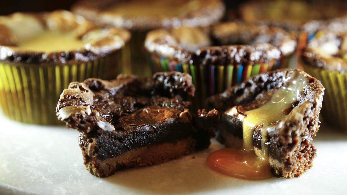 Reese’s Peanut Butter Cups nest in the bottom of these brownie cupcakes. Twix bars make a tasty substitute.