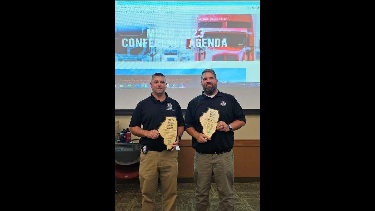 Kentucky State Police Detective Steve Spurlock and Criminal Intel Analyst Gary Thomas pose for a photo after being rewarded for their efforts in the takedown of a Kentucky cargo theft ring over the course of an 18-month long operation.