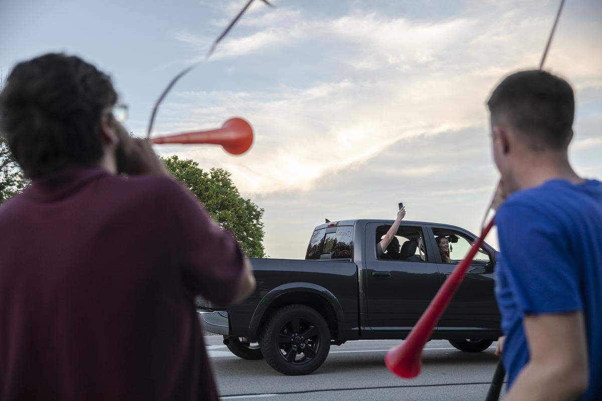 Onlookers cheer as a parade of Pulaski County High School graduates and their families makes its way from the school to Twin 27 Drive-in Theater May 30 where a grad video was premiered in Somerset.