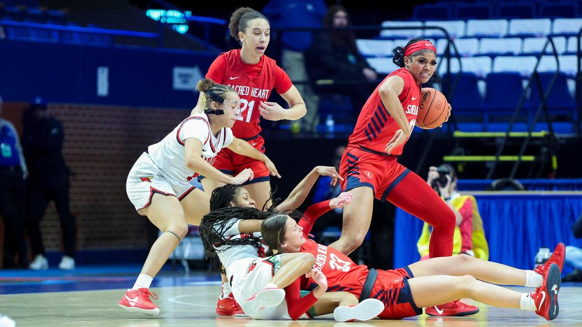 Sacred Heart’s ZaKiyah Johnson (11) comes up with a loose ball from a scrum of her teammates and George Rogers Clark players during Saturday night’s win. Johnson was named tournament MVP for an unprecedented fourth year in a row.