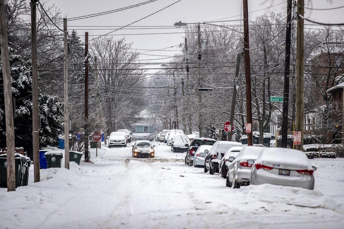 A car travels down snow covered Aylesford Place in Lexington, Ky., on Thursday, Feb. 18, 2021.