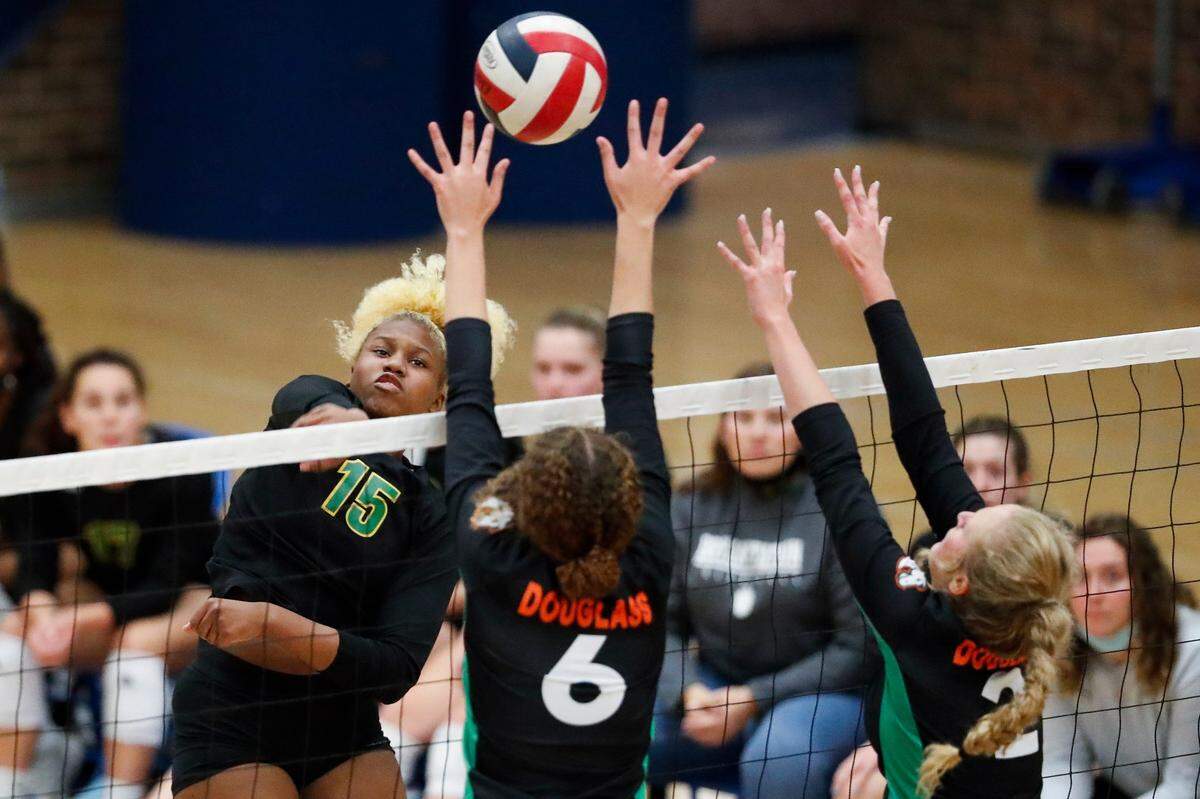 Bryan Station’s Cameron Owens (15) hits the ball past Carlee Smith (6) and Jamison Gordon (2) of Frederick Douglass during Wednesday night’s win.