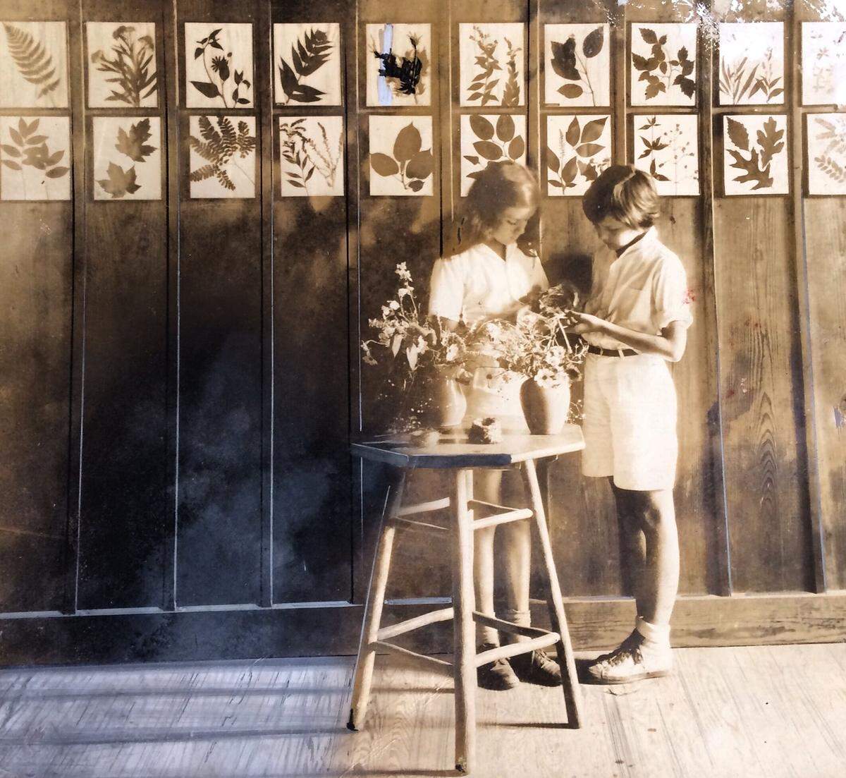 Trail’s End camp-goers play with flowers inside the now preserved lodge. The Trail’s End camp was established in 1913, and the lodge was built in 1917.