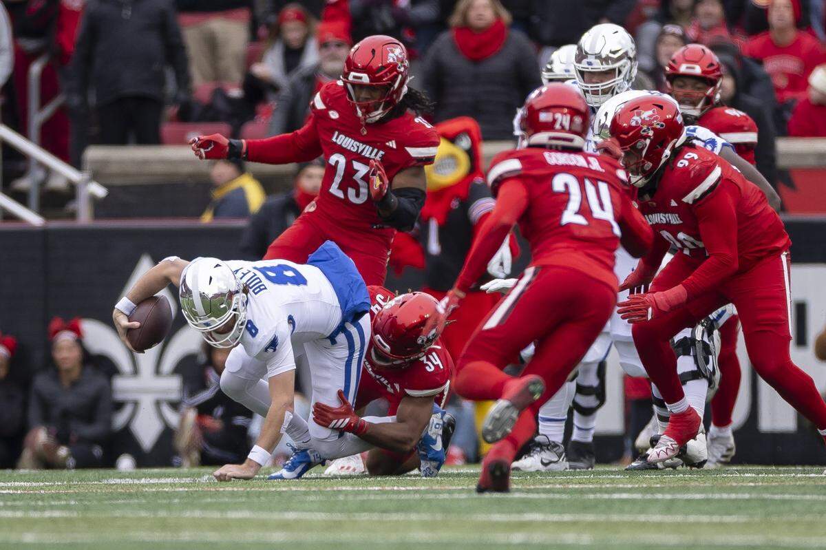 Kentucky quarterback Cutter Boley (8) is wrapped up by Louisville linebacker T.J. Quinn (34) during the Governor’s Cup game in Louisville.