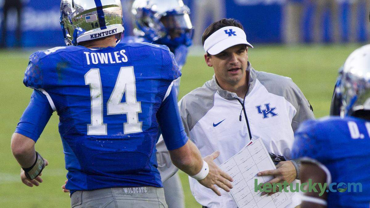 Kentucky Wildcats quarterback Patrick Towles (14) is met by offensive coordinator Neal Brown after scoring as the host University of Kentucky lost 31-45 to Mississippi State University football team at Commonwealth Stadium on Saturday October 25, 2014 in Lexington, Ky.  Photo by Mark Mahan