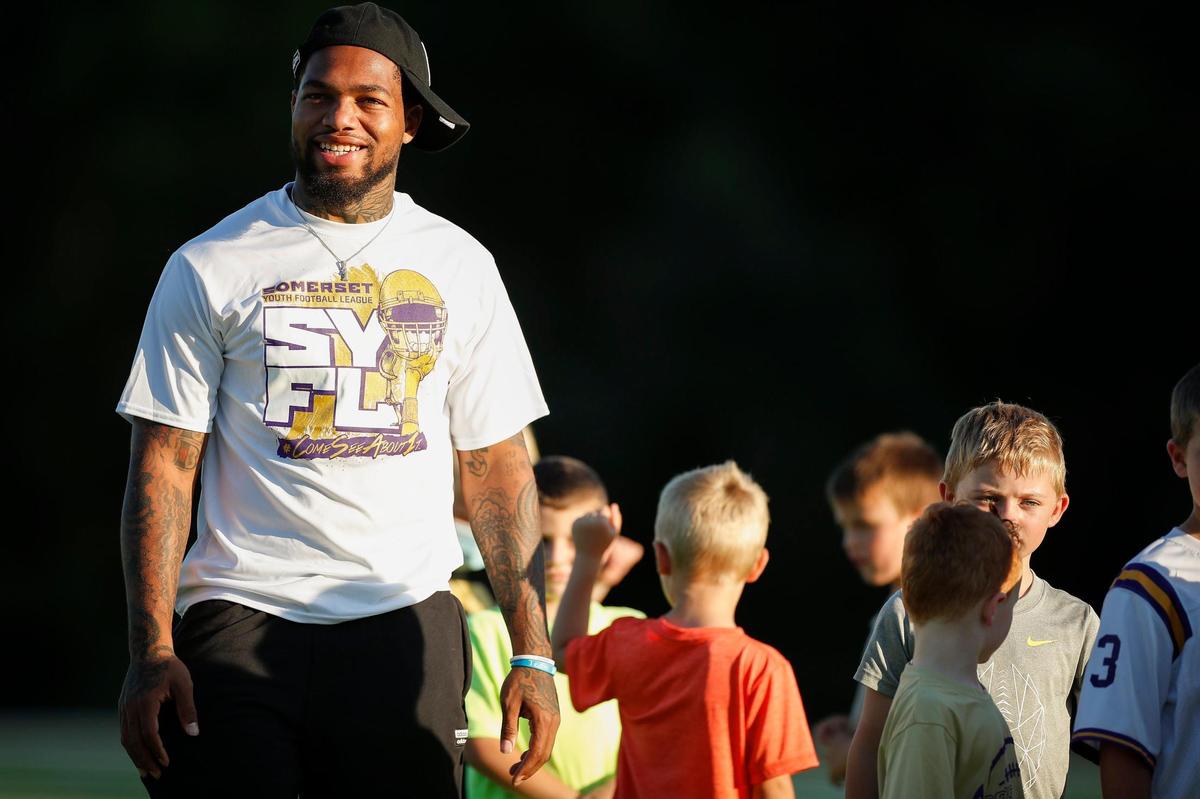 Lynn Bowden joked with UK inside linebacker Marquez Bembry and wide receiver Josh Ali, not pictured, during the Somerset Youth Football League camp on Saturday evening.