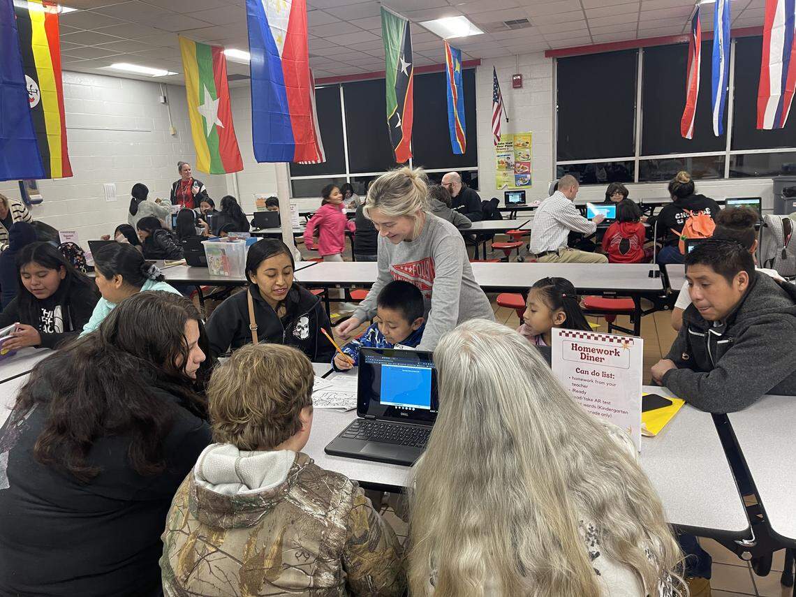 Staff and community partners gather with students and families at a homework dinner at Foust Elementary School in Owensboro.