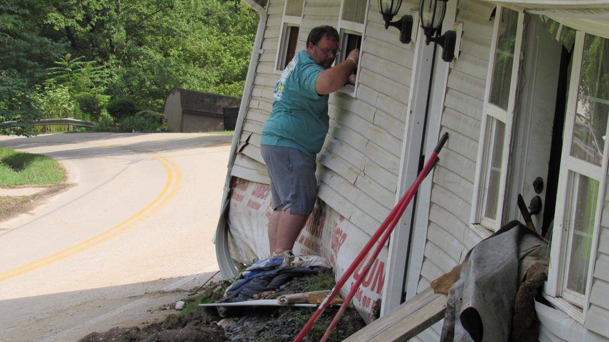 Reggie Ritchie stands outside his wrecked house near the Perry-Knott County line a few days after the deadly July 28, 2022 flooding in Eastern Kentucky. His wife was inside trying to salvage items and handing them to him out the window.