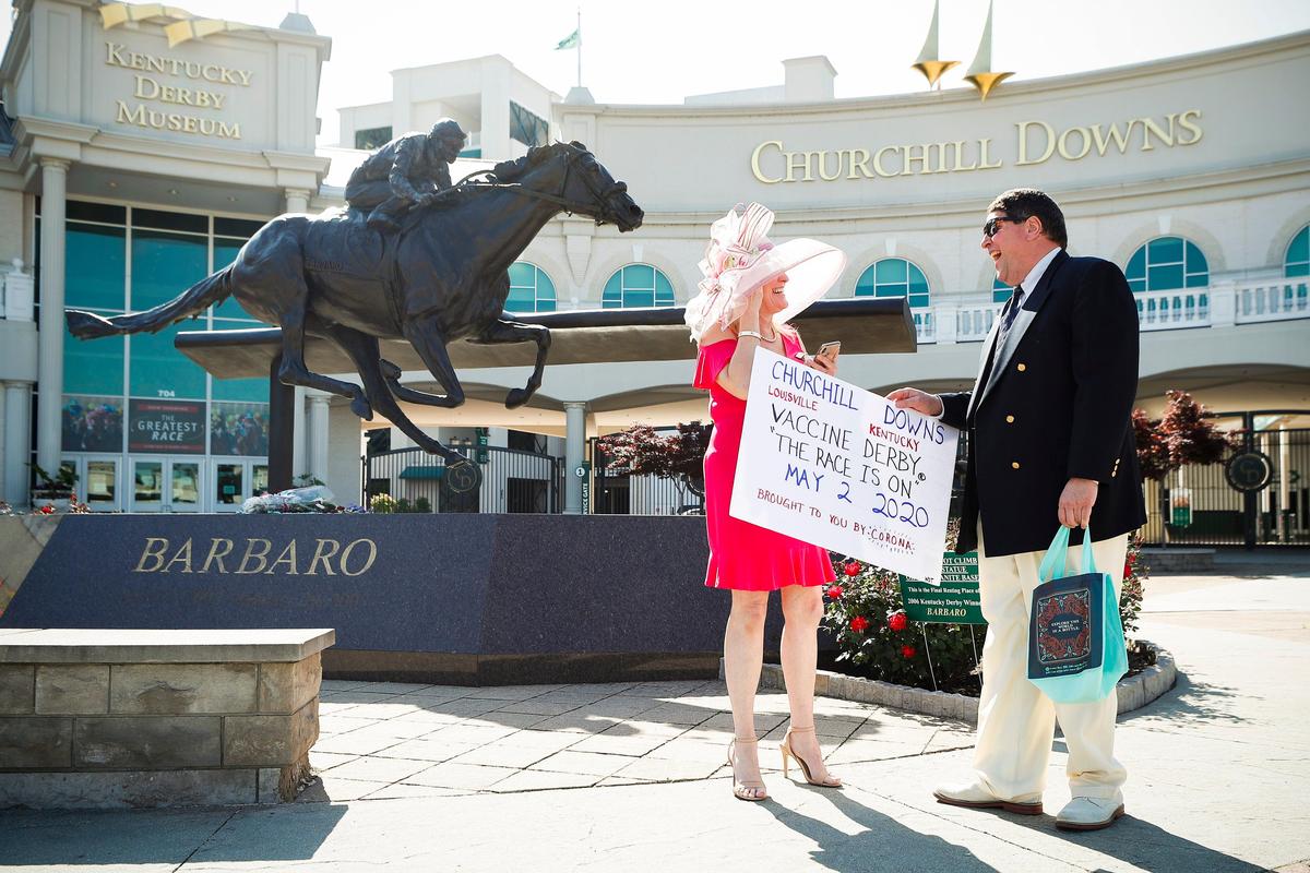 Catherine Blase, left, and Bill Teskoski, both of Shelbyville, joked while waiting to have their picture taken at the Barbaro Memorial Statue in front of Churchill Downs on Saturday. It should have been Kentucky Derby Day had the event not been postponed to Sept. 5 because of the coronavirus. “It’s the ‘Vaccine Derby.’ It’s not the Kentucky Derby,” Teskoski said.
