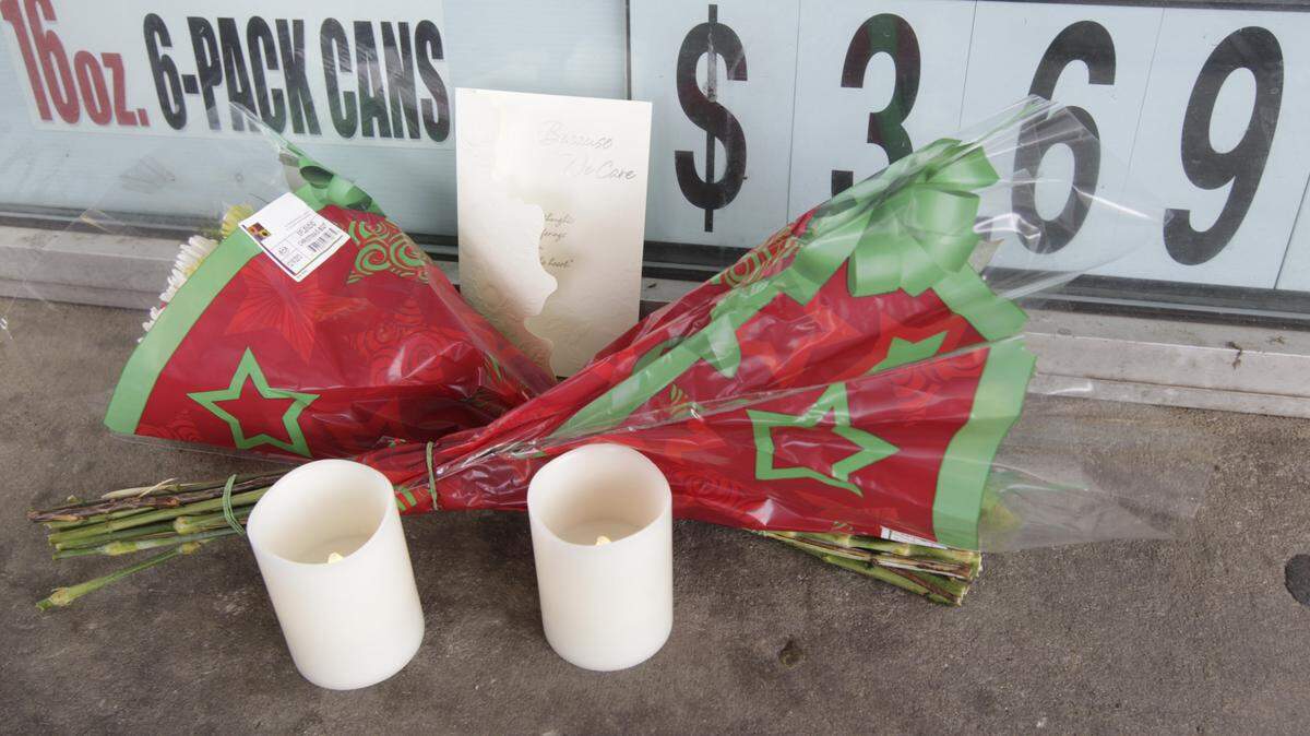 Candles, flowers and a card were left outside at the Marathon station on Alexandria Dr. in Lexington, Ky., on Dec. 10, 2013.  A robbery a day earlier, Dec. 9, left the cashier dead.  Photo by Pablo Alcala | Staff