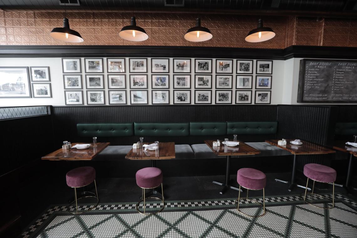 The wall of photos includes famous horses like Secretariat and Seattle Slew as well as famous horse trainers, owners and breeders.