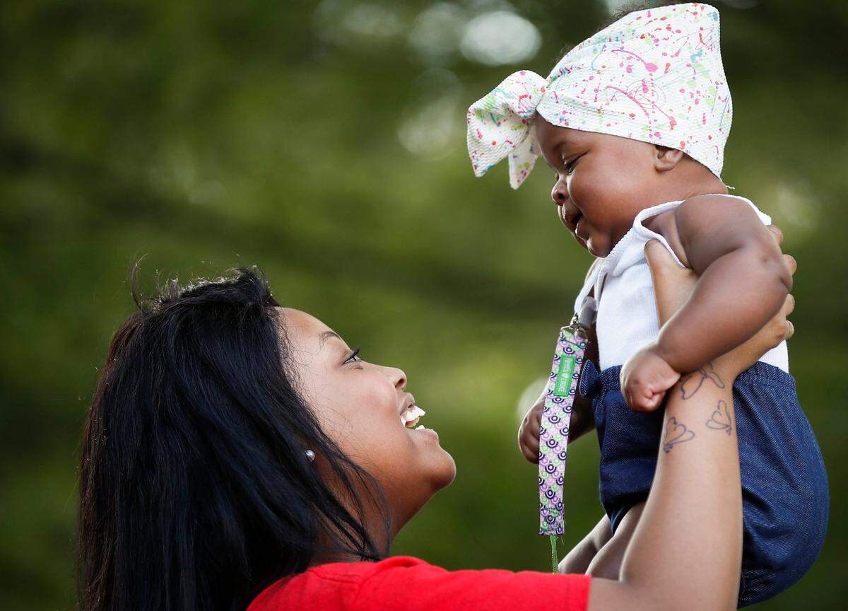 Azzareya Morris plays with her 7-month-old cousin Remi Burton, both of Winchester, Ky., during a Juneteenth ceremony at Heritage Park in Winchester, Friday, June 19, 2020.