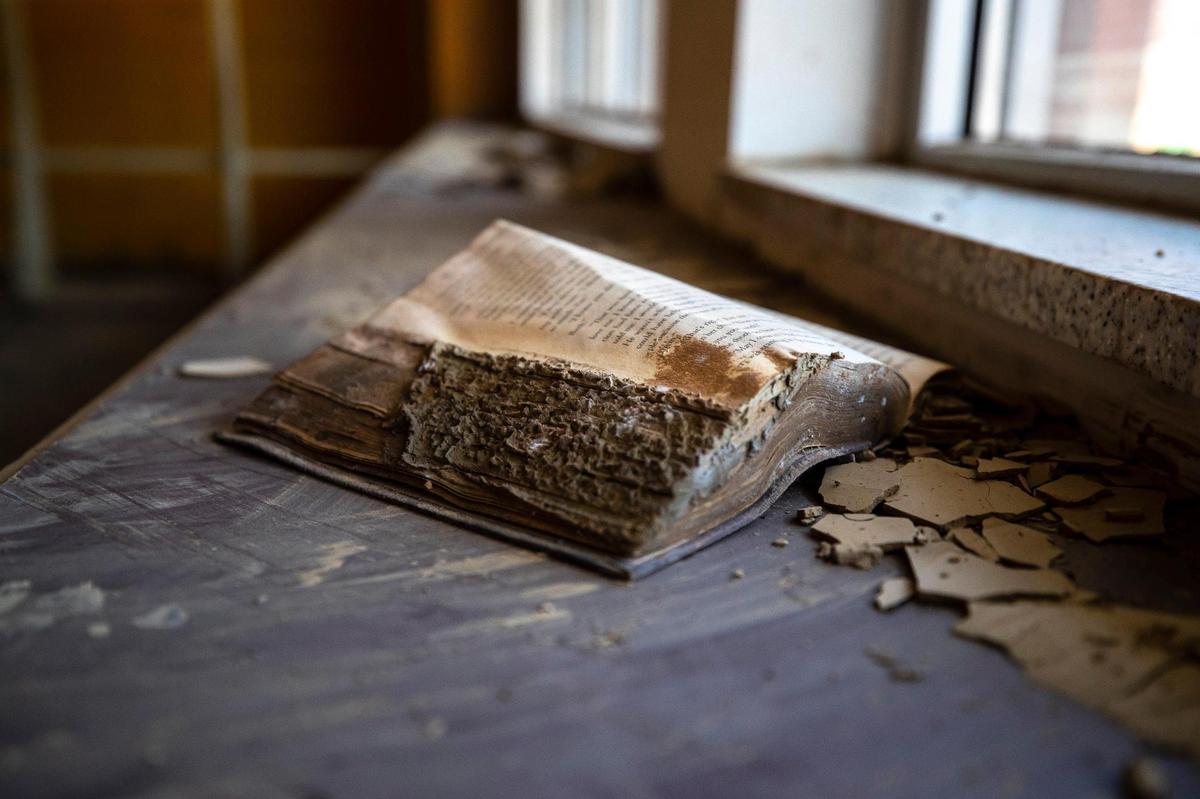 A book, caked in mud, rests on a shelf at the Fleming-Neon Public Library in Fleming-Neon, Ky., on Wednesday, Aug. 31, 2022. The library was damaged by flooding in late July.