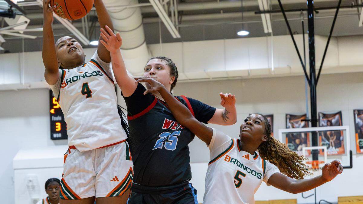 Douglass's Tamia Waide (#4) goes for a two-point layup against Jessamine's Kimberly Johnson (#25), with teammate Peighton Okorley (#5) assisting with the rebound during the West Jessamine vs Frederick Douglass girls basketball game on Jan. 14, 2026, in Lexington, Ky.