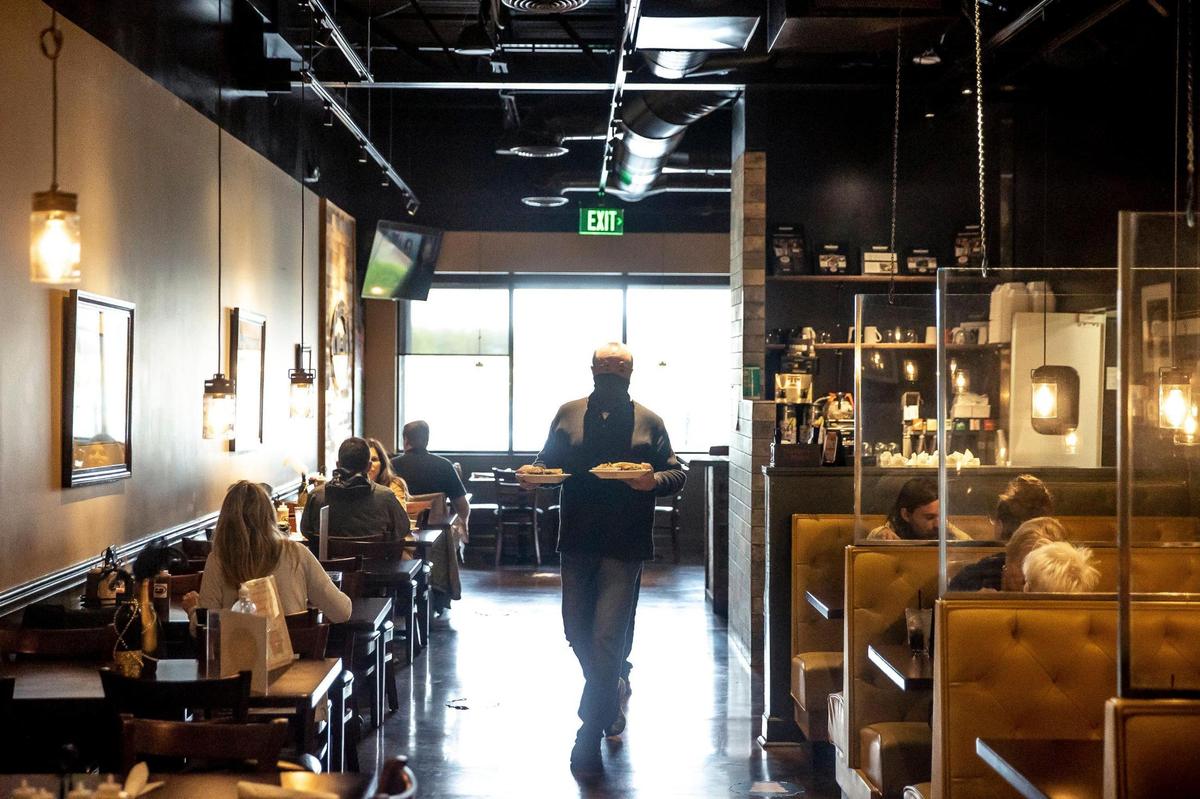 Ren Everly, co-owner of J. Render’s Southern Table & Bar, delivered a lunch order to a customer’s table in April.
