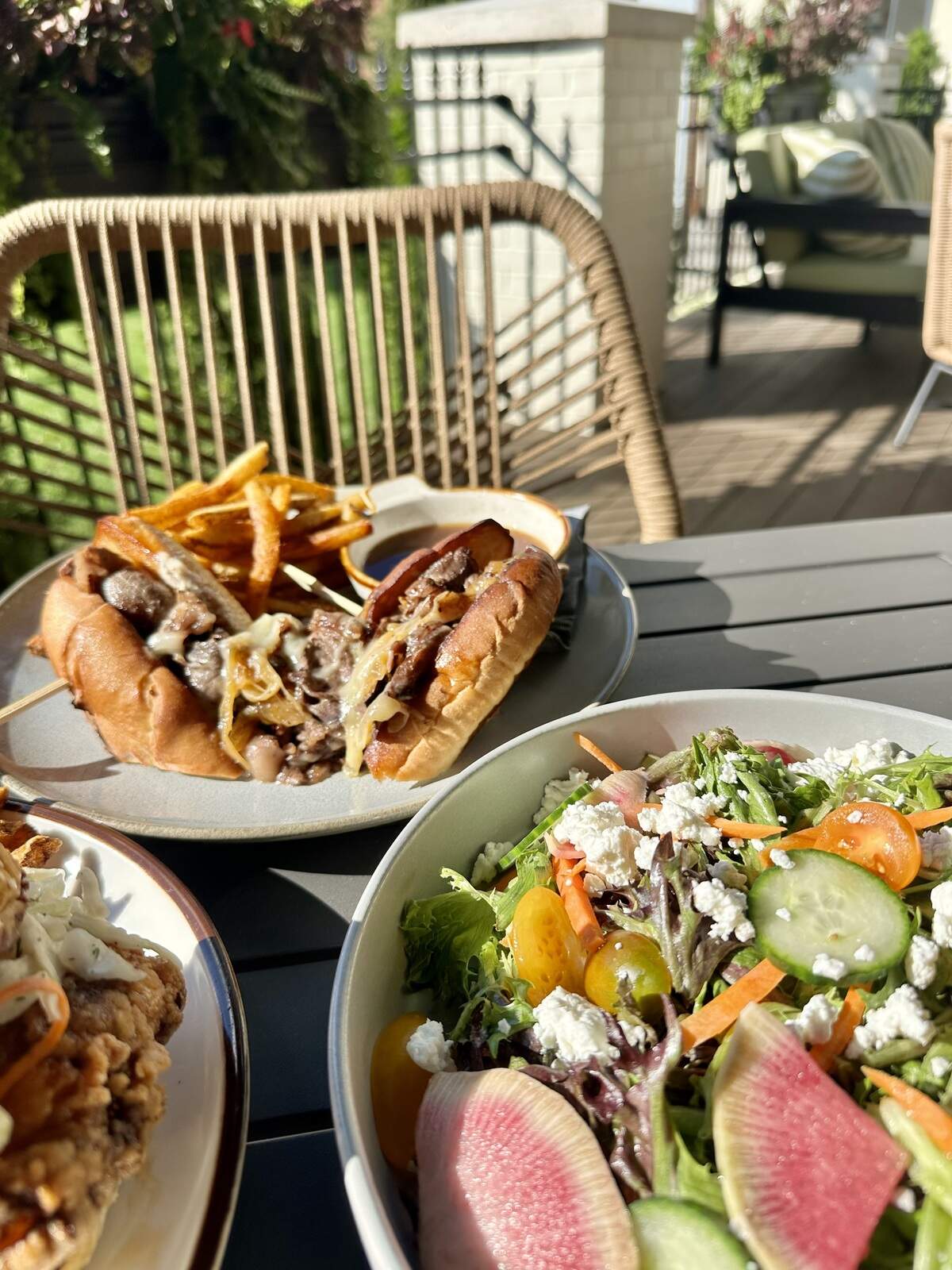 Millstone’s farmhouse salad (foreground) features field greens, carrot, radish, cucumber, tomato, goat cheese, honey vinaigrette ($13) while the prime rib sandwich (background) is made with shaved smoked beef, caramelized onions, horseradish aioli, provolone, au jus on a house baguette ($21).