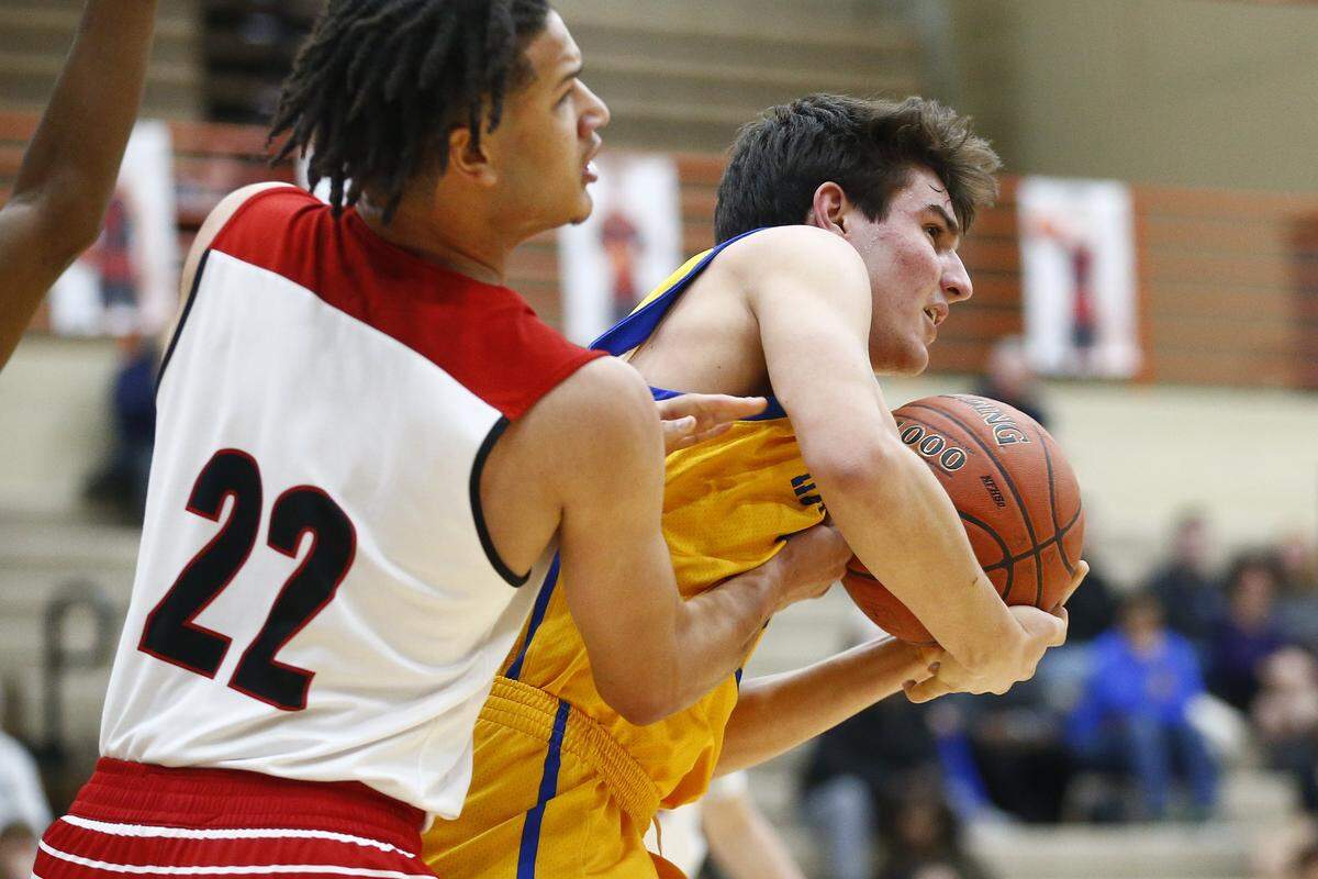 Paul Laurence Dunbar’s Michael Corio (22) and Henry Clay’s Harris Hawkins (32) battled for the ball during their game Thursday at Dunbar. Henry Clay won 66-50.